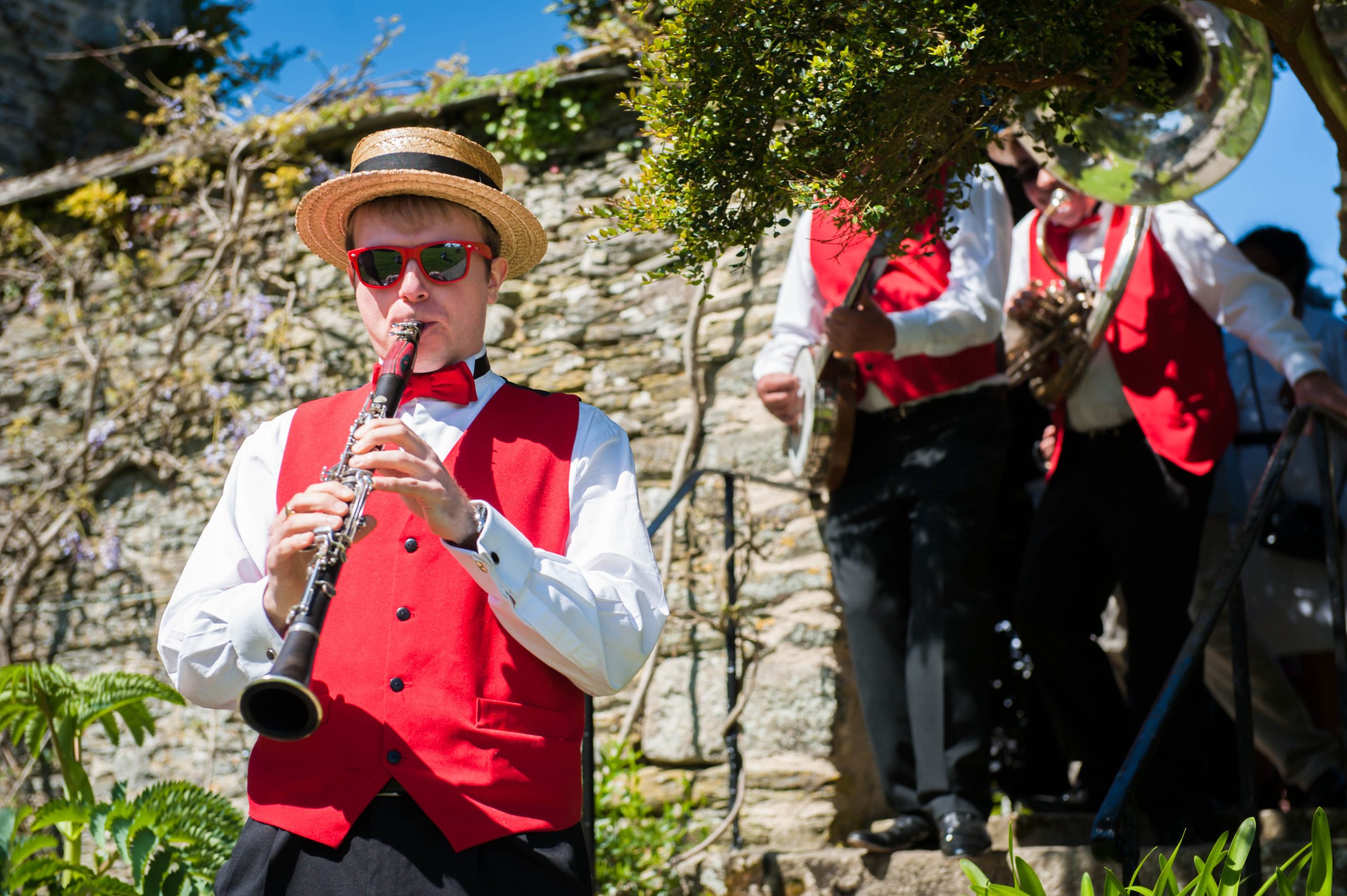 Silk Street Jazz 13 Roaming jazz band at an outdoor event providing live music. Clarinettist wears read waistcoat and straw hat and red sunglasses