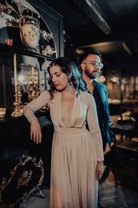 vocal duo, male female standing together posing by a bar